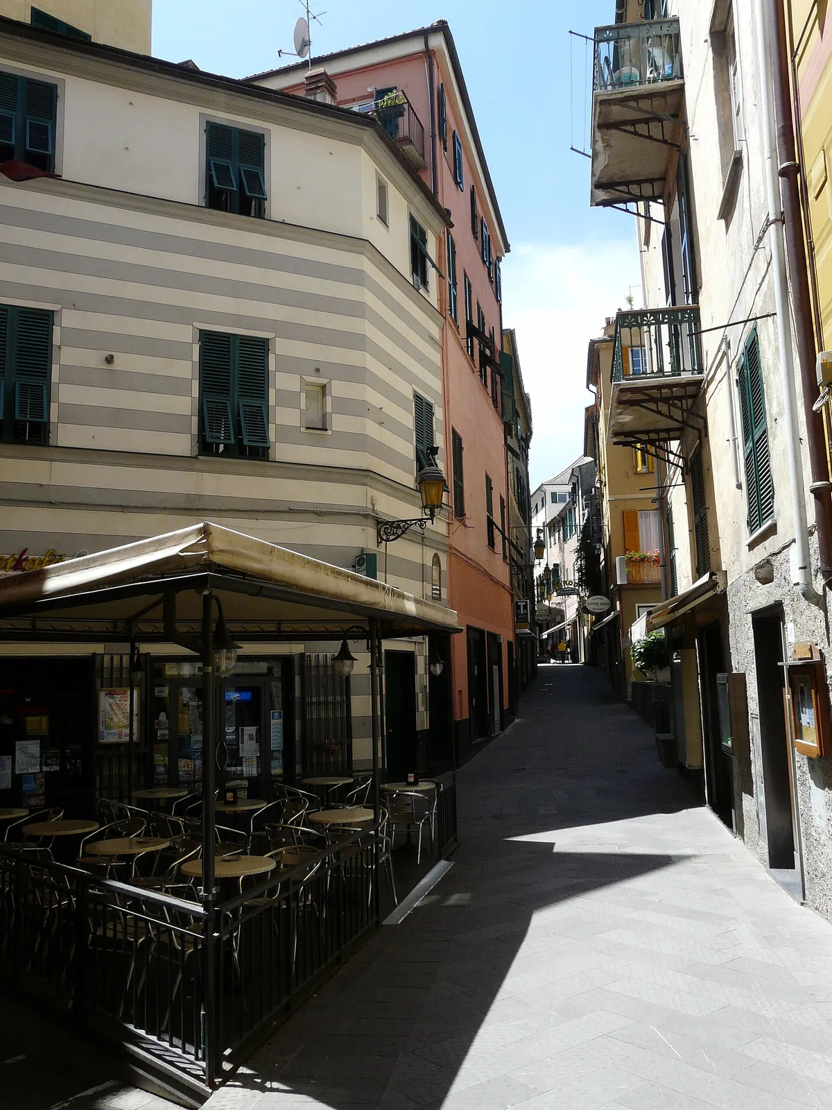 Un carruggio del centro storico di Arenzano con i tavolini di un bar